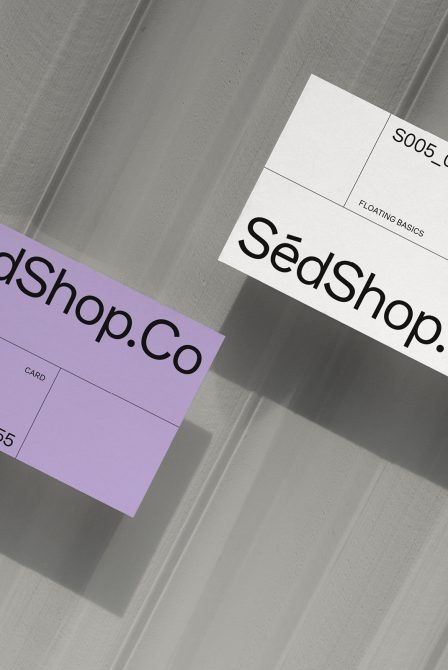 Elegant business card mockup in shadow on grey surface for graphic designers, presenting a minimalist branding layout with modern typography.